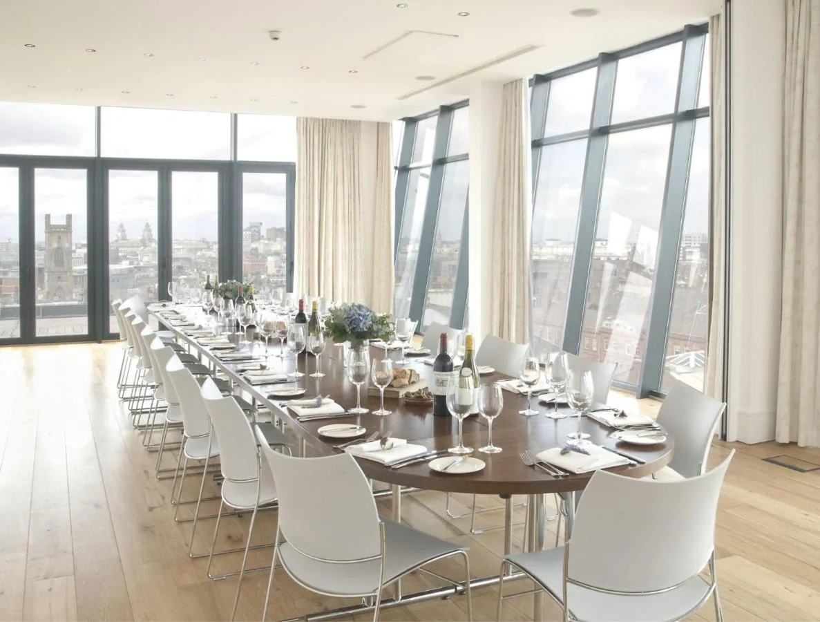 a long dining room with a long table and white chairs at Hope Street Hotel in Liverpool